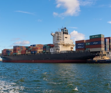 black cargo ship on sea under blue sky during daytime
