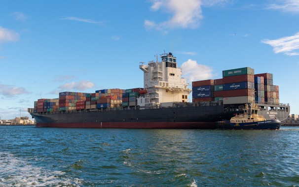 black cargo ship on sea under blue sky during daytime