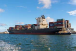black cargo ship on sea under blue sky during daytime