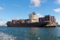 black cargo ship on sea under blue sky during daytime