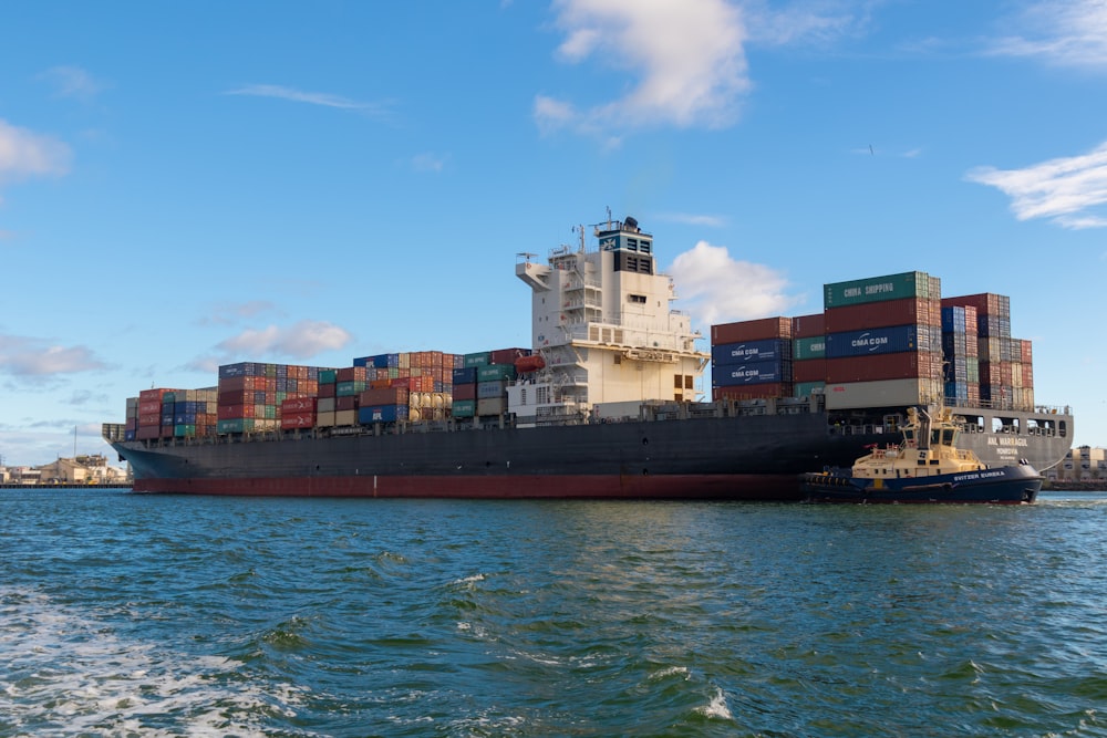 black cargo ship on sea under blue sky during daytime