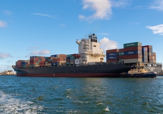 black cargo ship on sea under blue sky during daytime