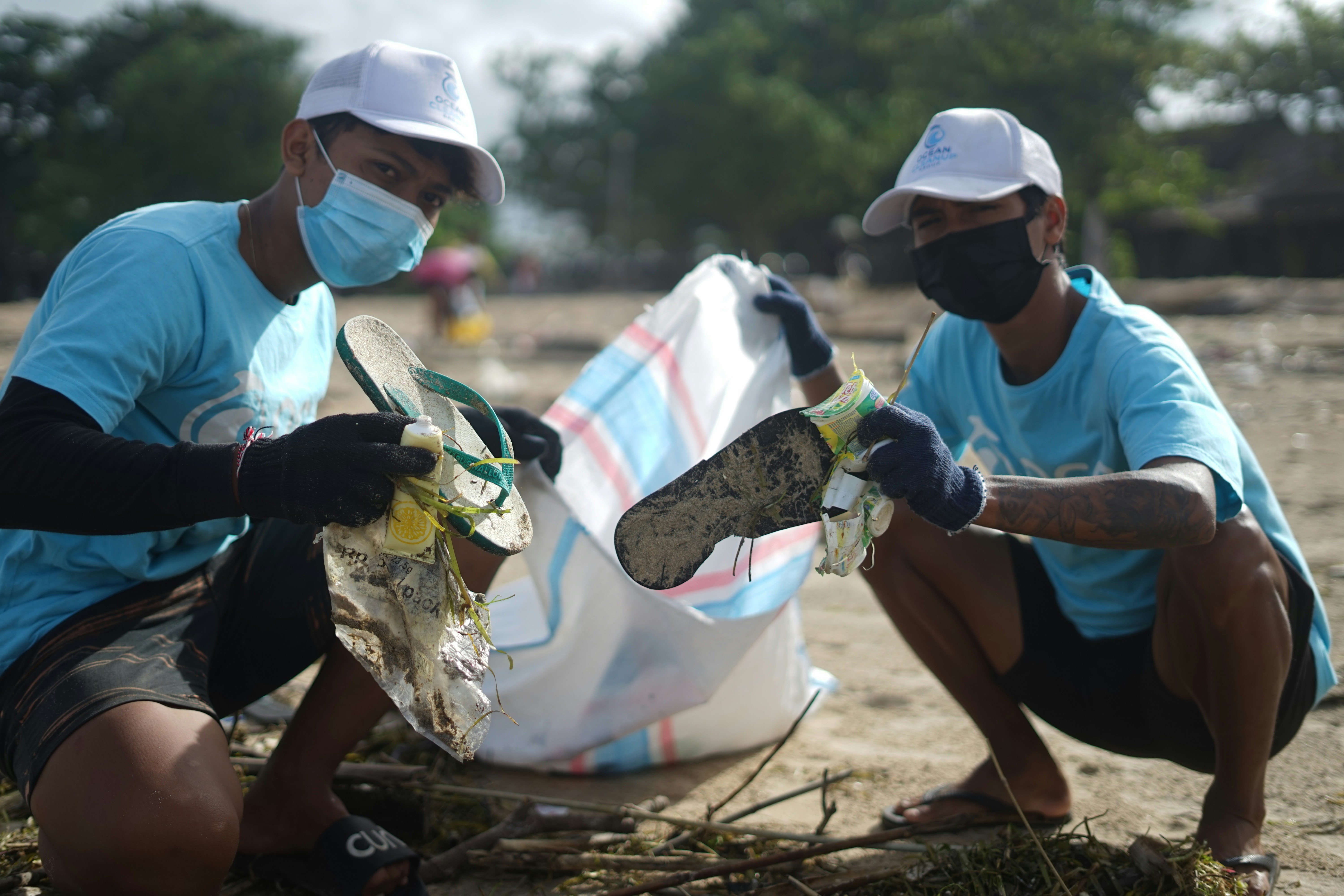 homem na camisa branca e shorts pretos carregando bolsa de couro marrom e preta