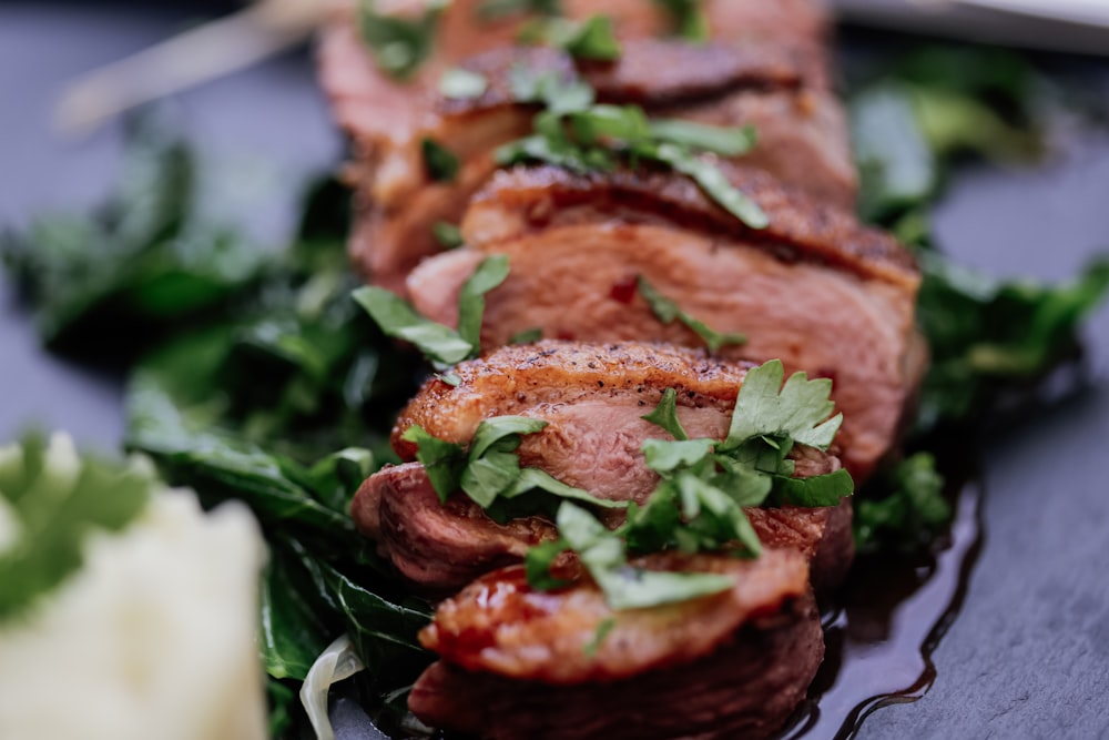 grilled meat with green vegetable on white ceramic plate