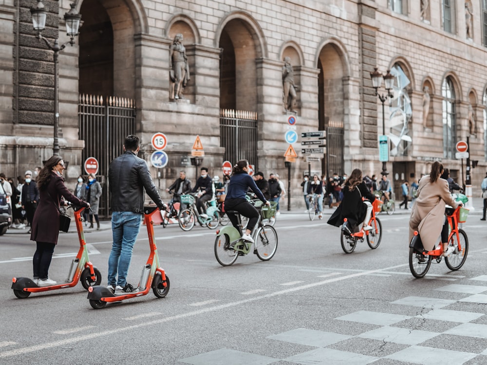 people riding bicycles on road during daytime