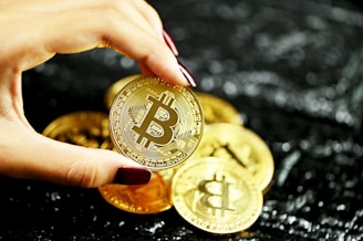 gold round coin on persons hand