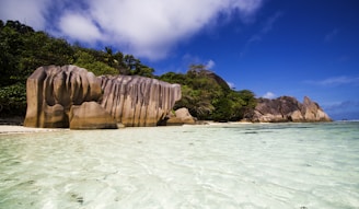 brown rock formation on body of water under blue sky during daytime
