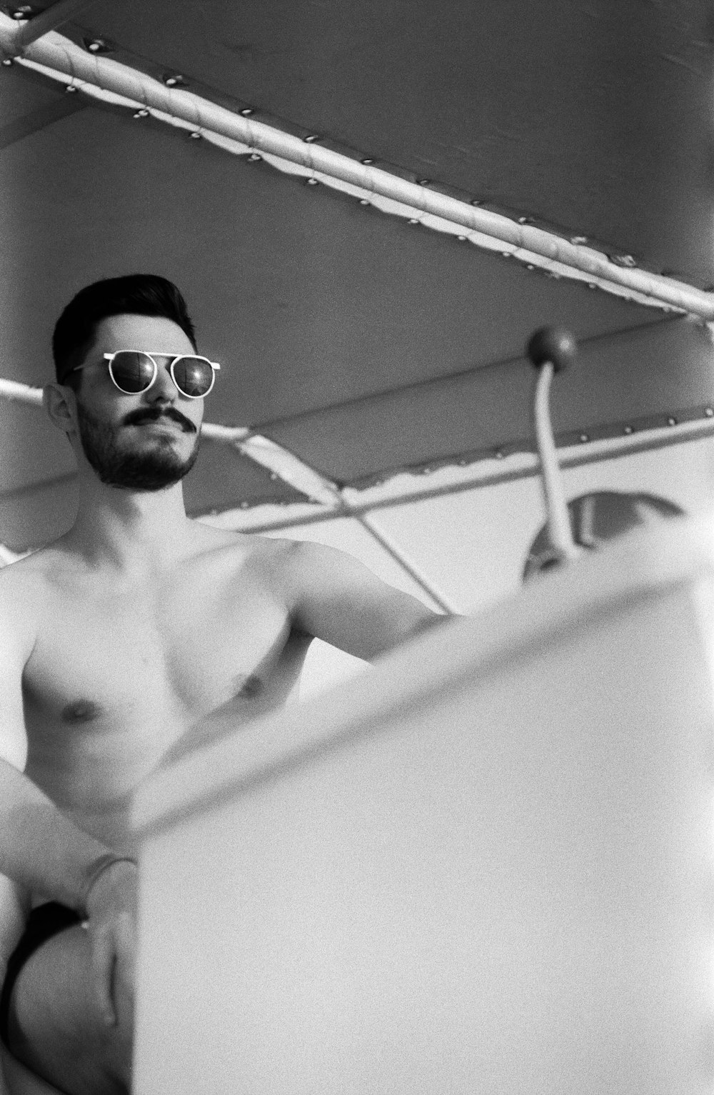 topless man wearing black sunglasses in bathtub