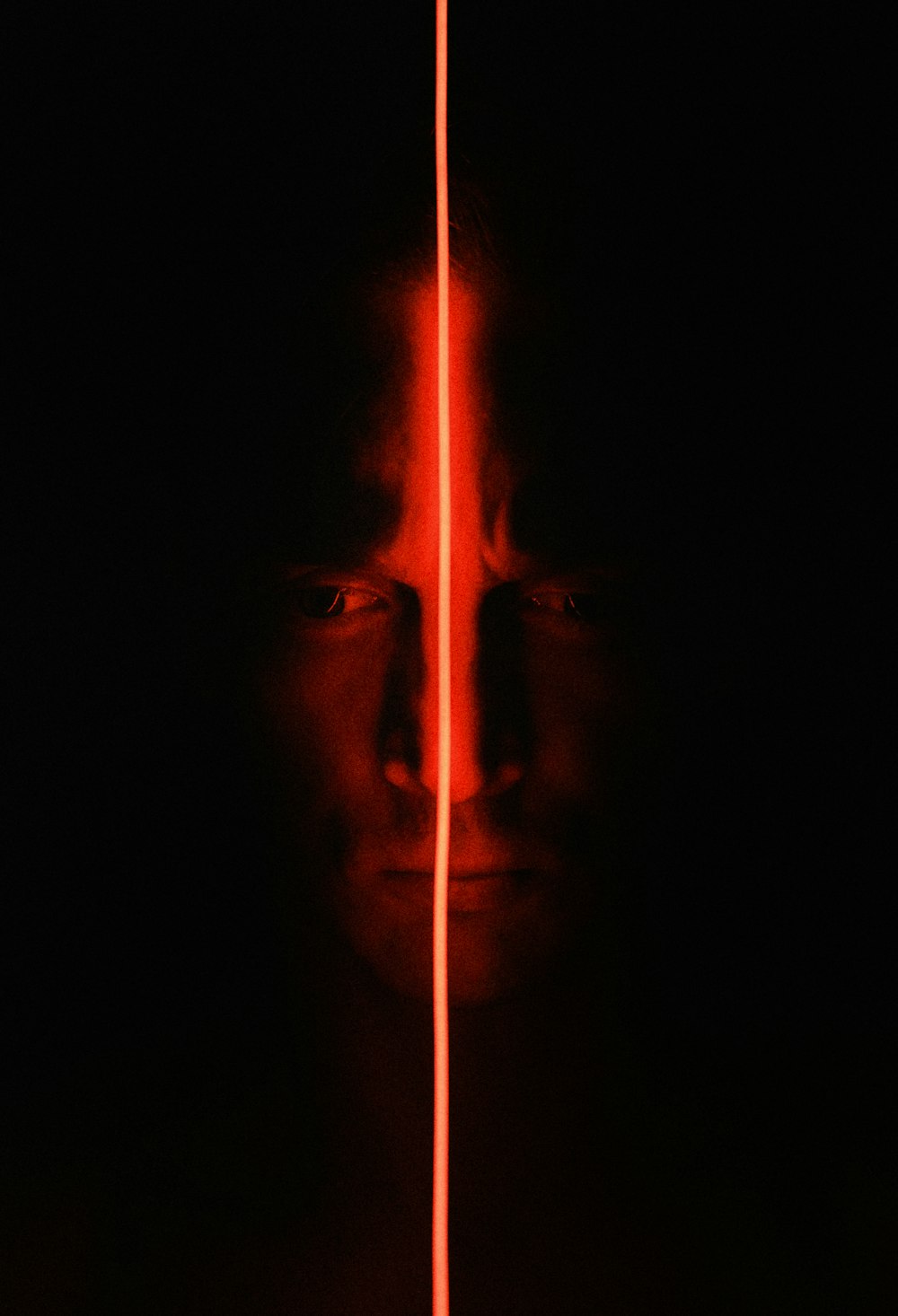 Face in the dark, crossed by a line of red light — see clearly, before you decide