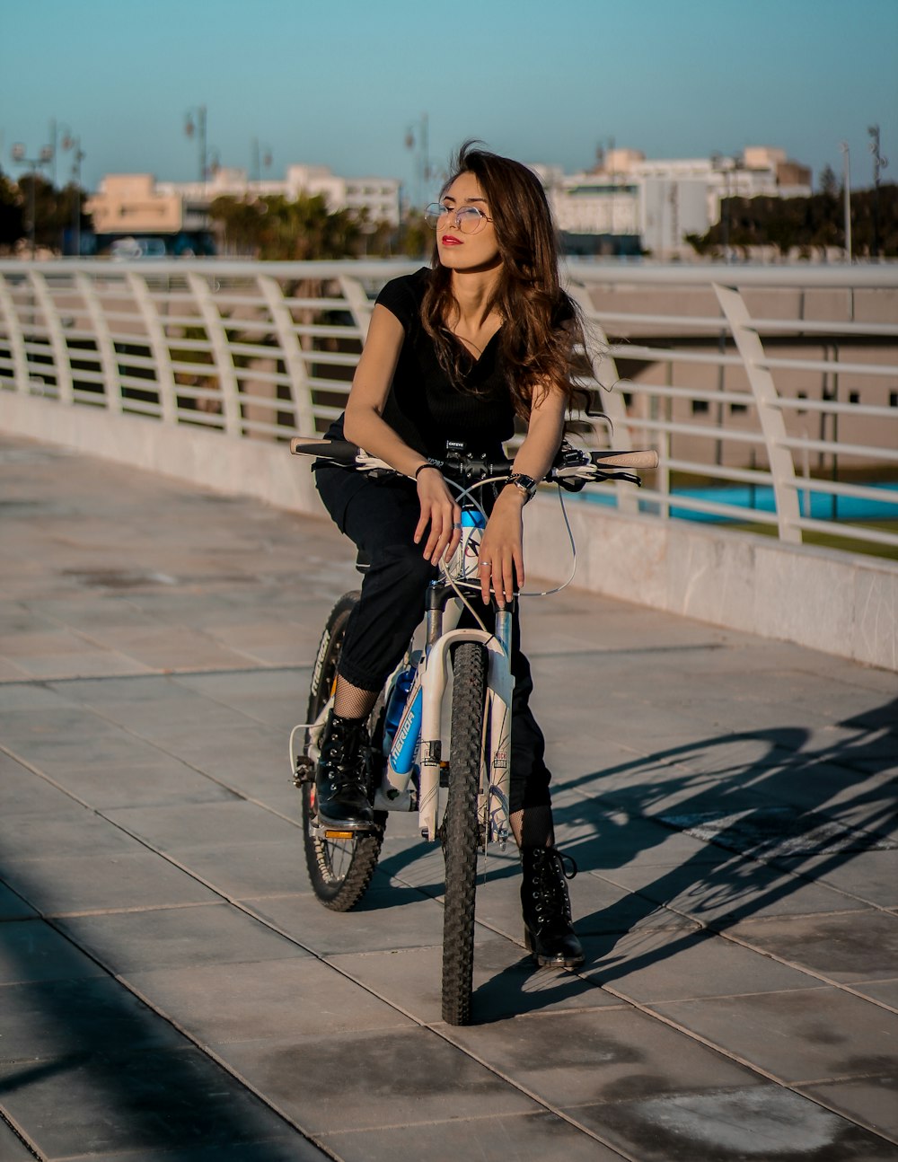 woman in black tank top riding on bicycle during daytime