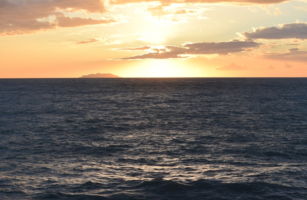 body of water under cloudy sky during daytime