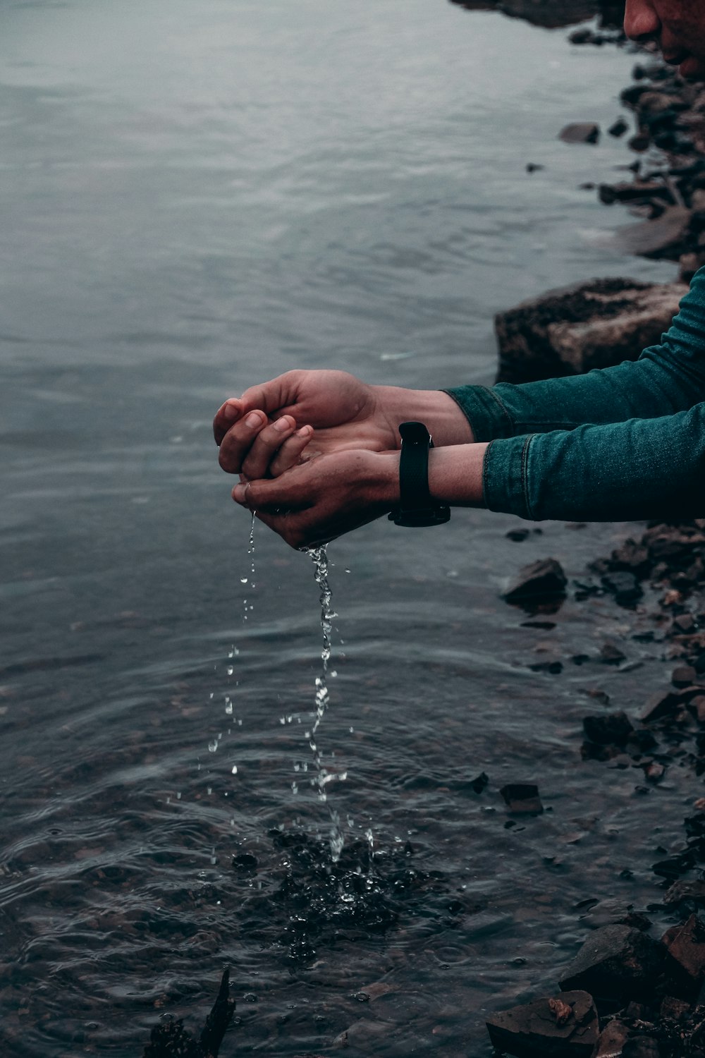 person in blue long sleeve shirt holding water