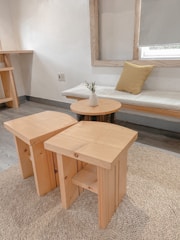 Handcrafted tufted rug laid out in a bright, minimalist room with pastel accents.