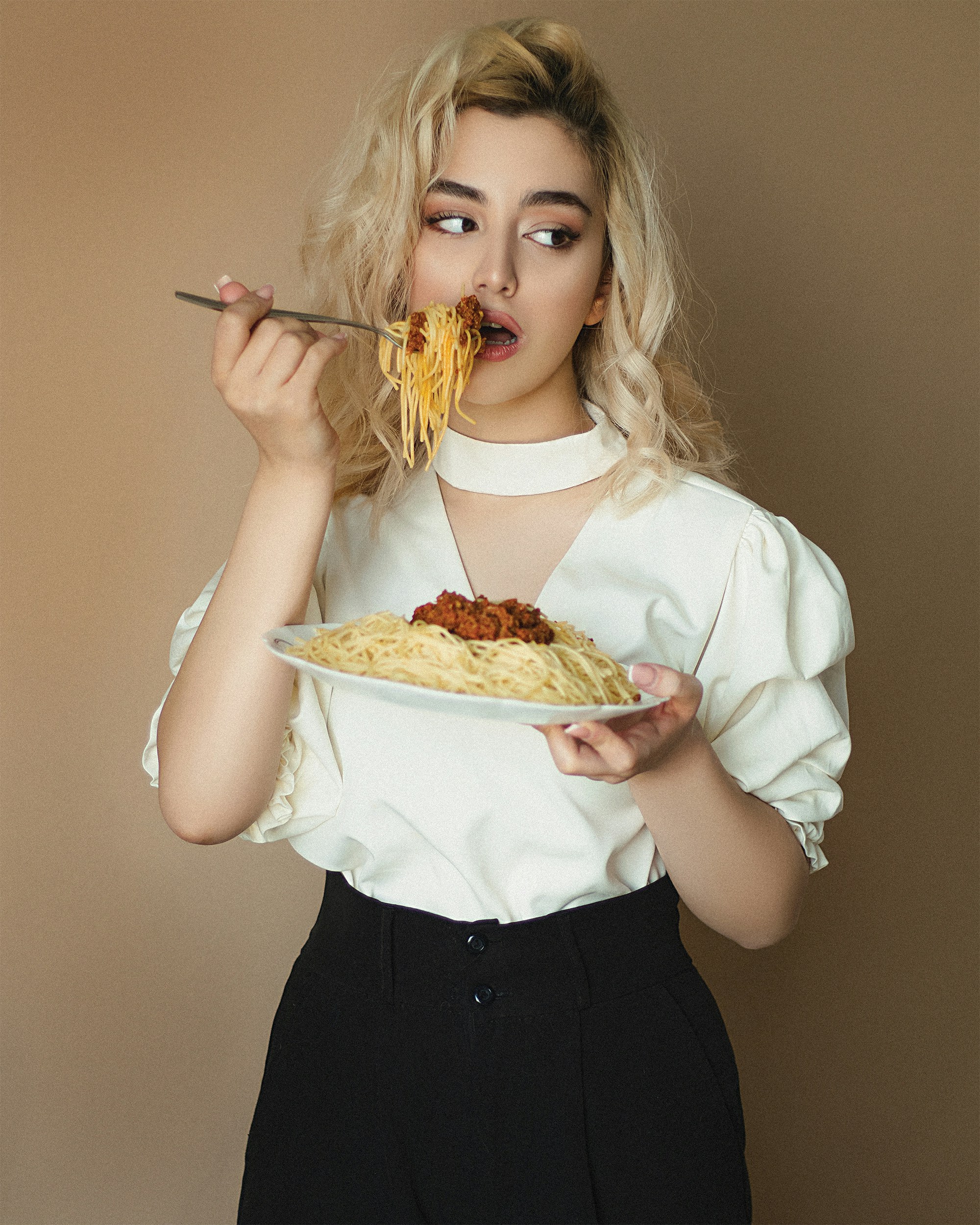 great photo recipe,how to photograph woman in white long sleeve shirt holding fork and eating pizza