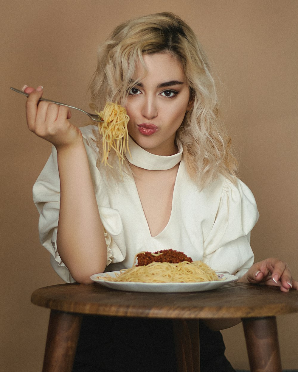 woman in white dress shirt eating pizza