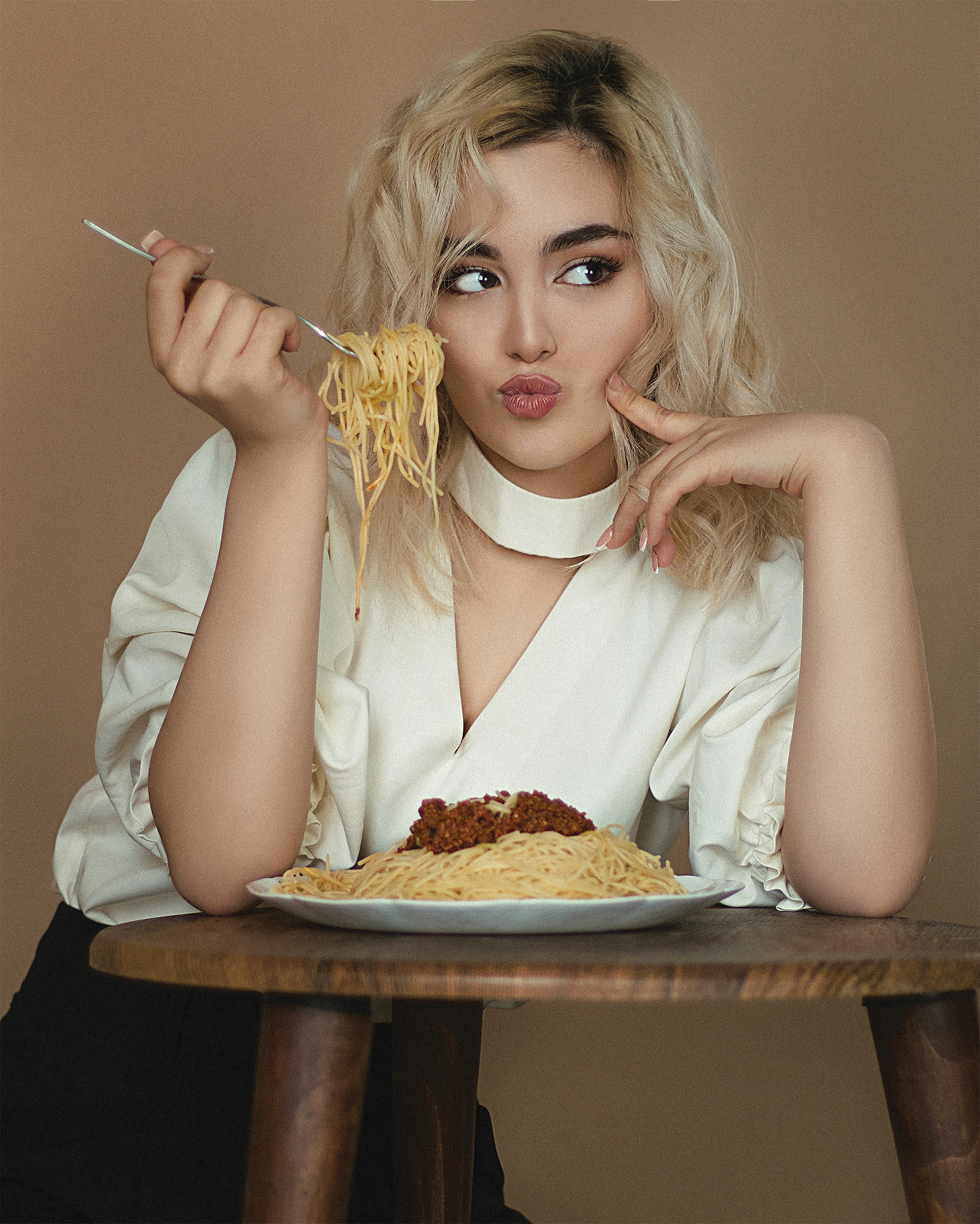 Femme en chemise blanche tenant une pizza tranchée