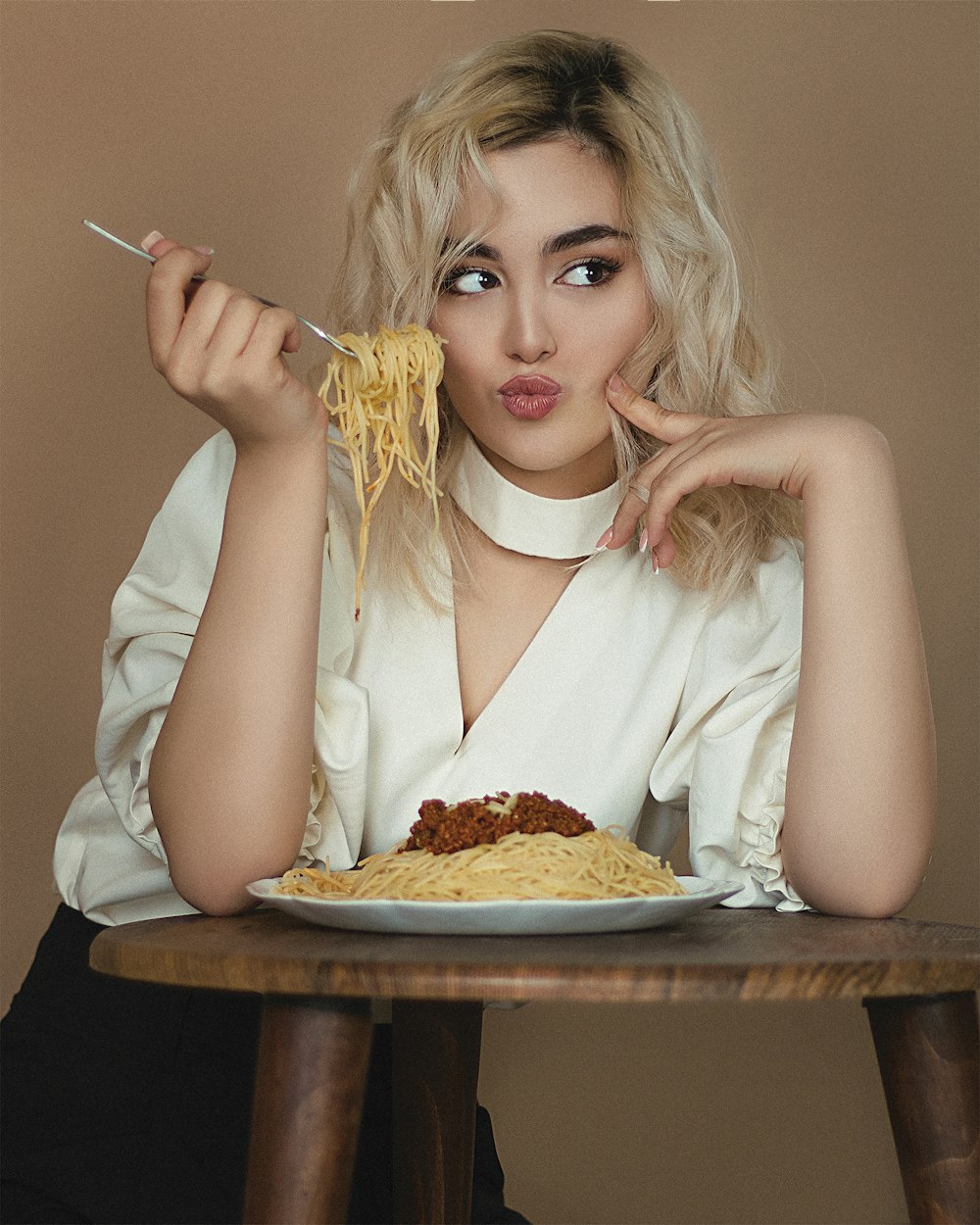 woman in white dress shirt holding sliced pizza