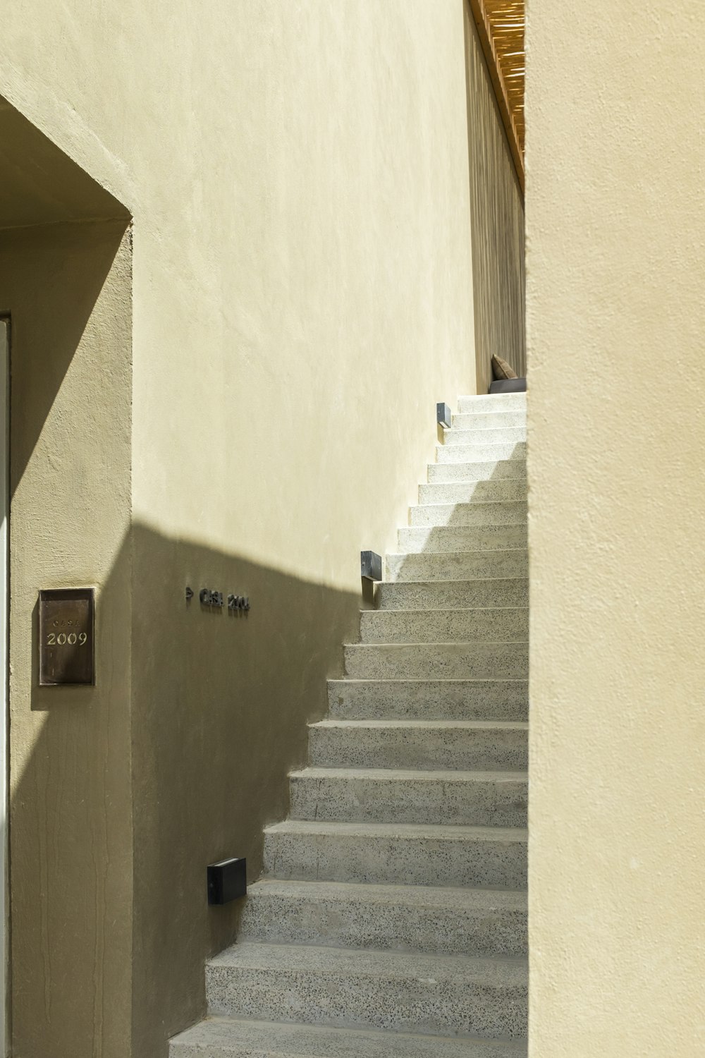 white concrete staircase with brown wooden door