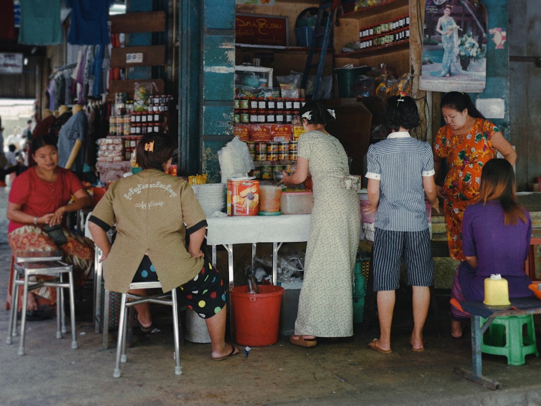 woman in green and white dress standing near woman in beige cardigan