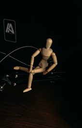 brown wooden human figure on black surface