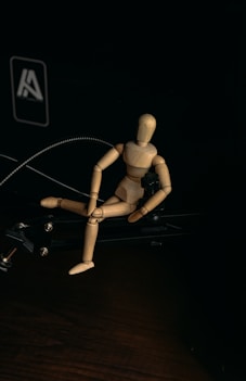 brown wooden human figure on black surface