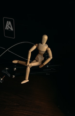 brown wooden human figure on black surface