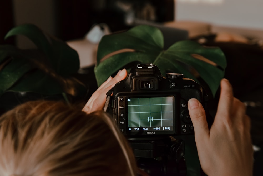 person holding black nikon dslr camera