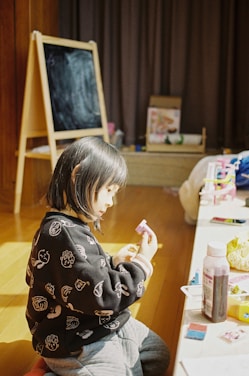 girl in black and white sweater sitting on floor