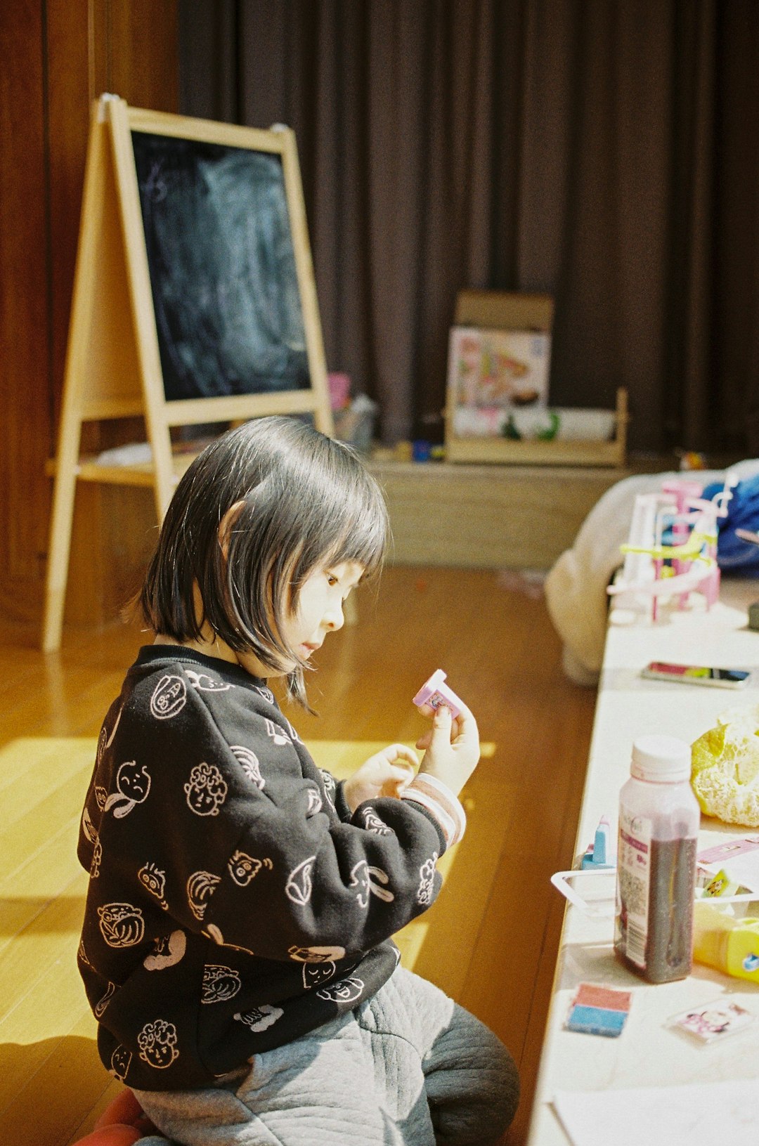 girl in black and white sweater sitting on floor