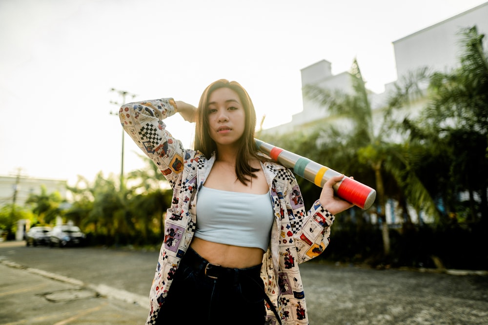 woman in white tank top and black and brown cardigan holding red and white plastic cup