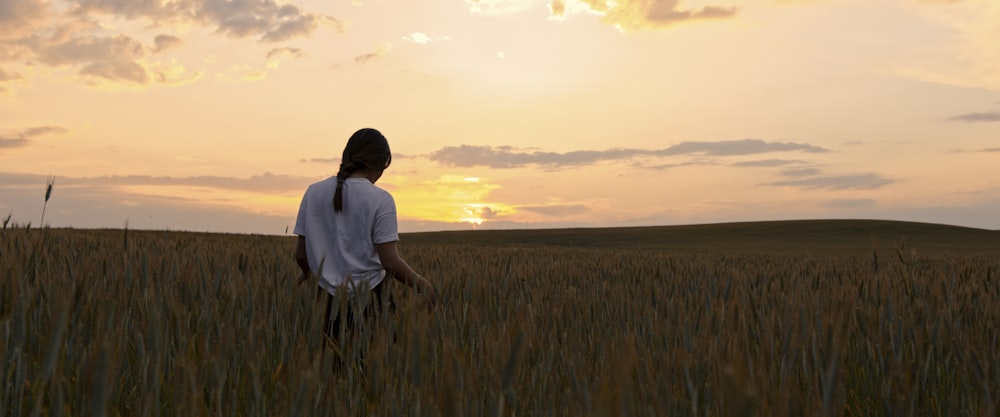 man in white shirt standing on green grass field during daytime