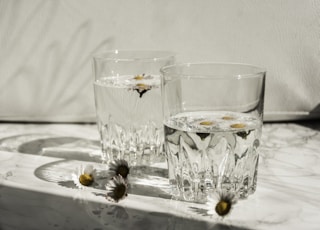 clear drinking glass on white ceramic plate