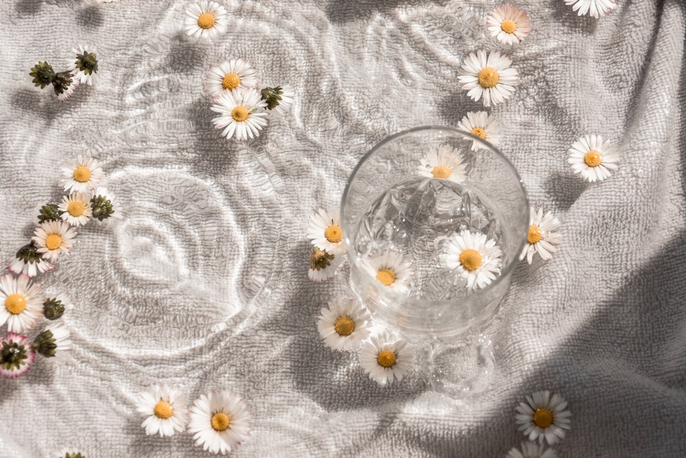 clear glass bowl on white floral textile