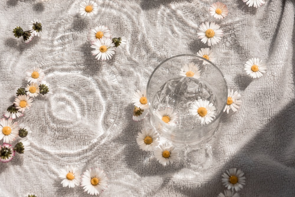 Cuenco de vidrio transparente sobre textil floral blanco