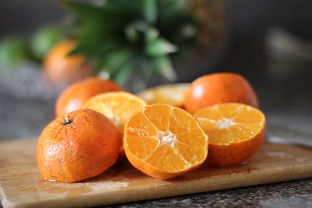 fruta laranja fatiada na bandeja de madeira marrom