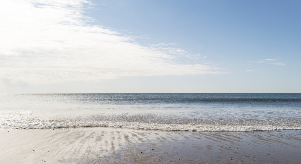 Brauner Sandstrand unter blauem Himmel tagsüber