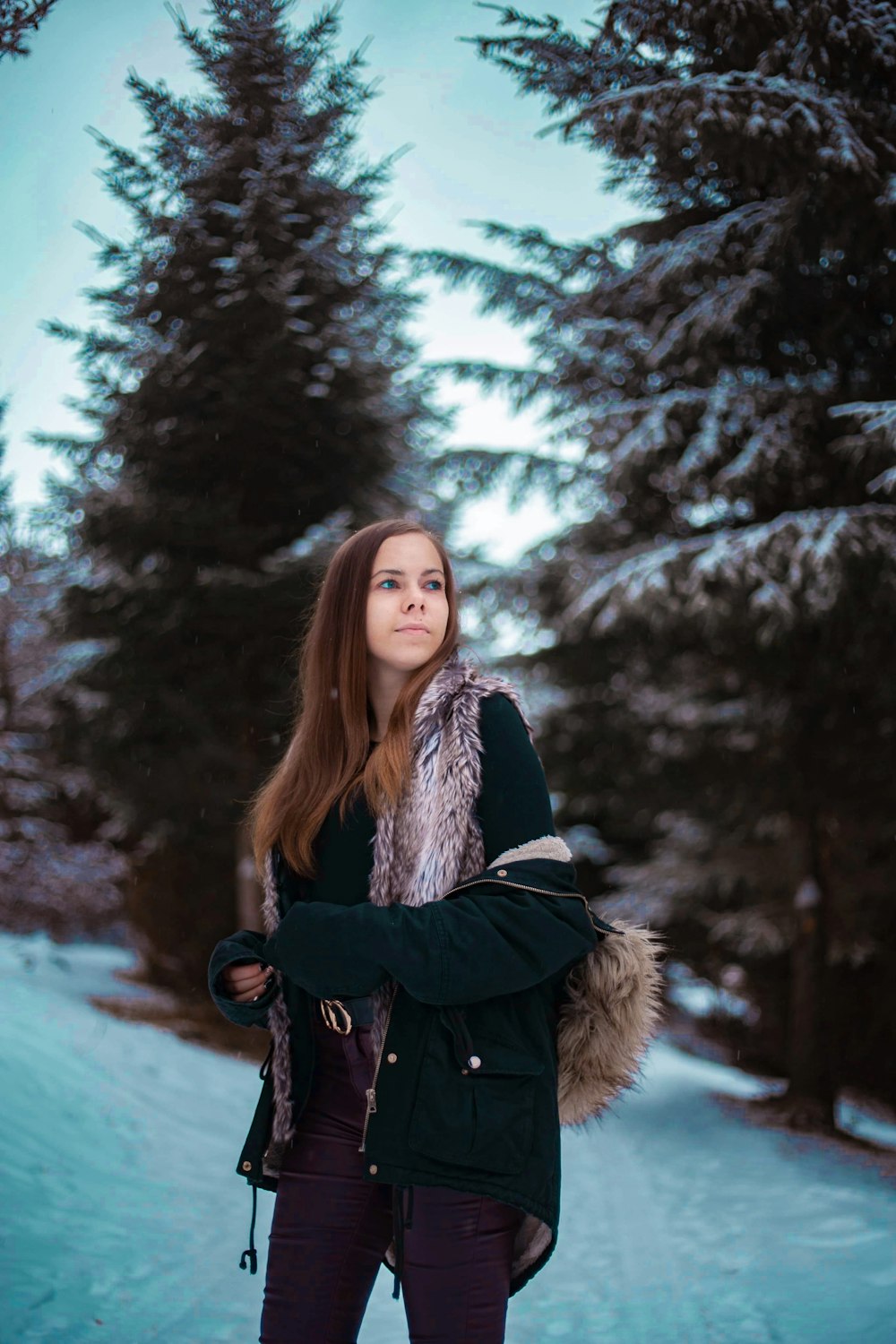 woman in black coat standing on snow covered ground during daytime