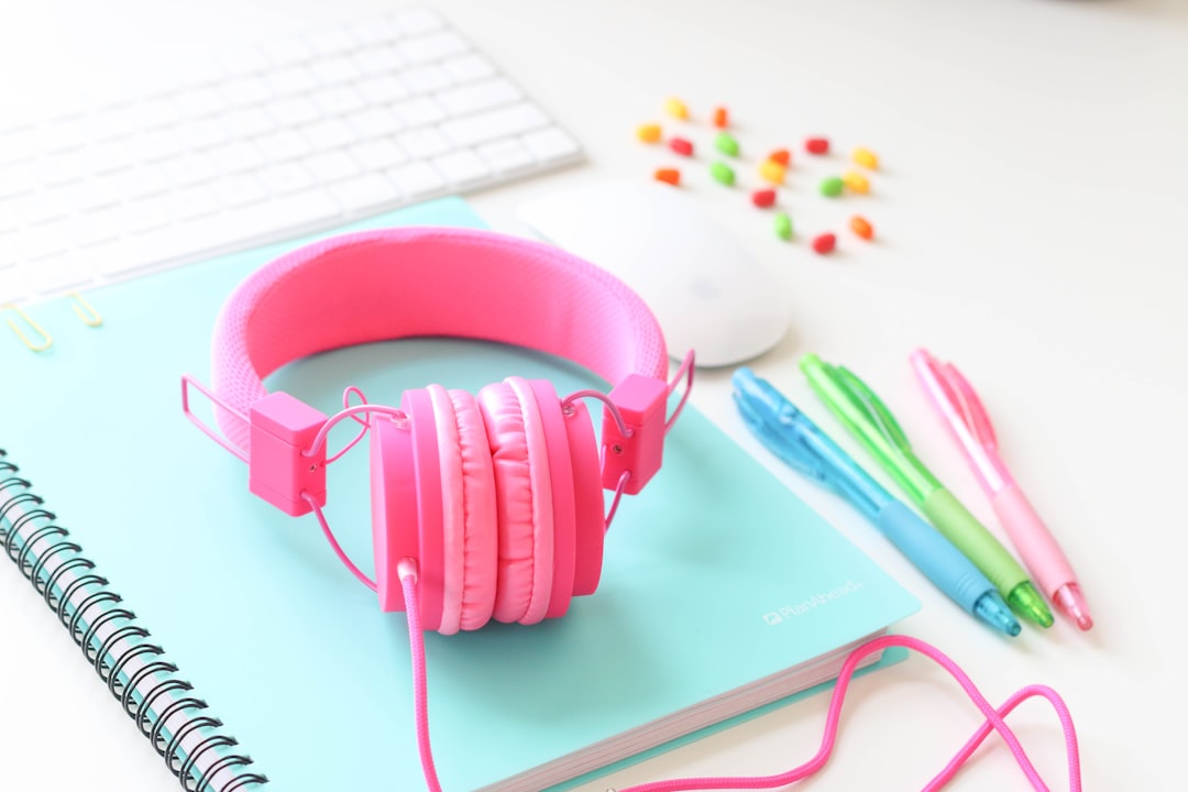 pink headphones on white laptop computer