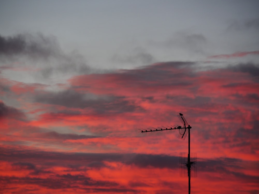 silhouette di turbine eoliche sotto il cielo nuvoloso arancione e grigio