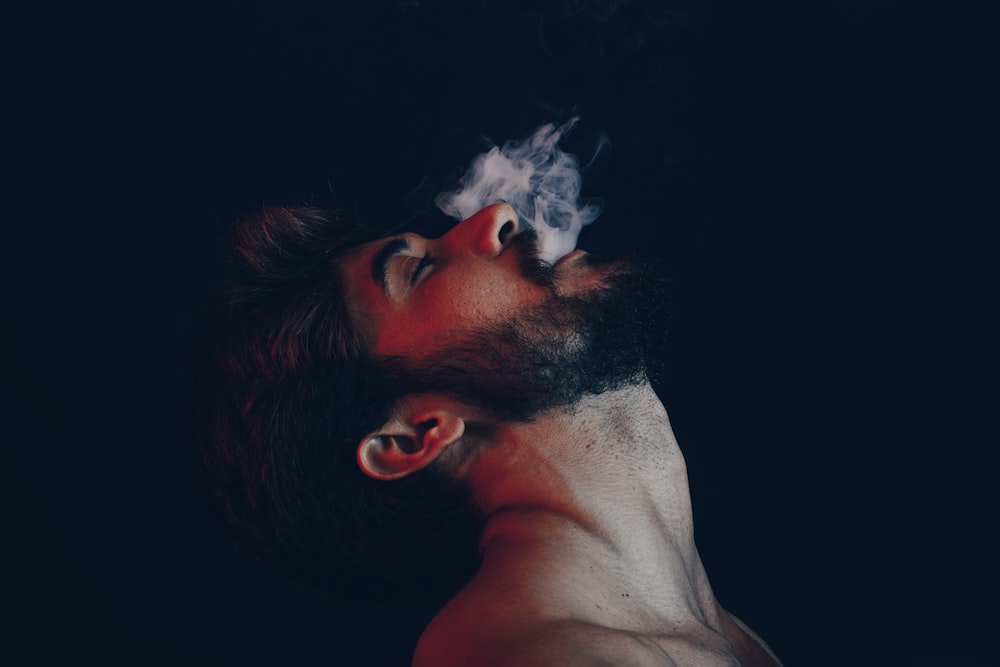 Mann mit weißem Rauch im Gesicht