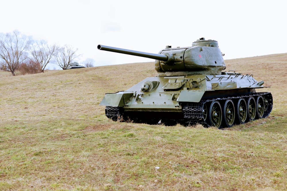 昼間の緑の芝生の上の緑の戦車