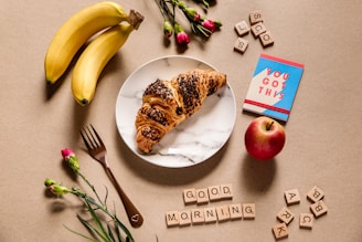 banana fruit and bread on white ceramic plate