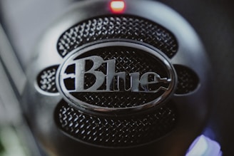 A clean, minimalistic microphone icon with blue accents on a white background