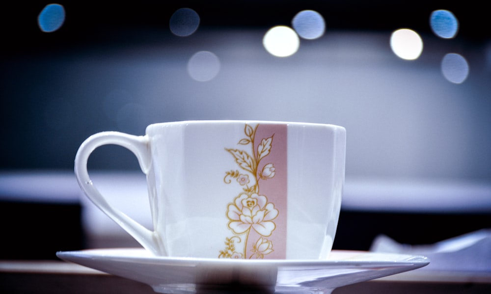 white and yellow floral ceramic mug on saucer