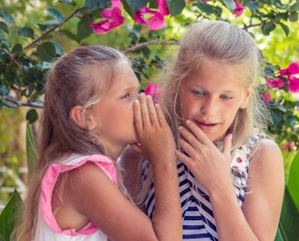 girl in pink tank top beside girl in blue and white striped tank top