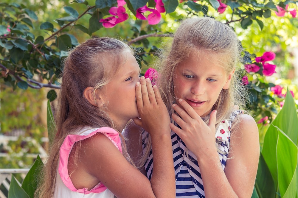 fille en débardeur rose à côté de fille en débardeur rayé bleu et blanc