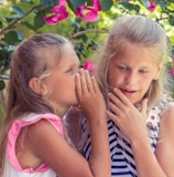 girl in pink tank top beside girl in blue and white striped tank top