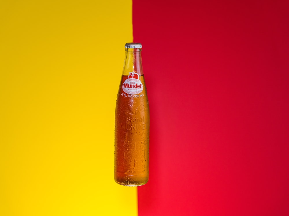 liquido arancione in bottiglia di vetro trasparente