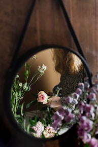 woman in black and white polka dot long sleeve shirt holding purple flowers