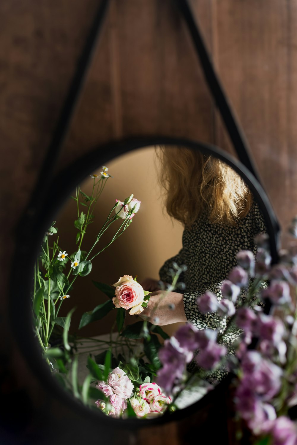 woman in black and white polka dot long sleeve shirt holding purple flowers